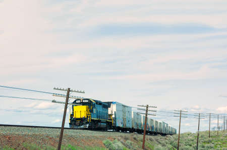 Milton Freewater, Oregon, USA -  March 23, 2016:  A freight train runs along rail tracks on it's...