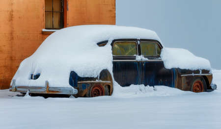 A old rusty auto sets exposed through many seasonal elements.  Snow layered will only add to it's demise.の写真素材