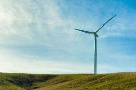 Windturbines stand tall and stark against the high desert landscape of rolling hills in the Columbia...