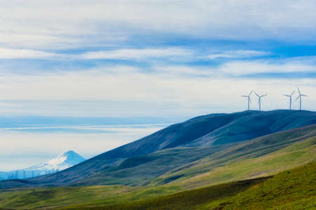 Windturbines stand tall and stark against the high desert landscape of rolling hills in the Columbia...