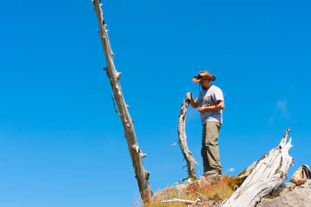 A male hiker wearing a hat and short sleeve t-shirt stands on the top of Castle Peak, near Mt. St. Helens in Gifford Pinchot National Forest.の写真素材