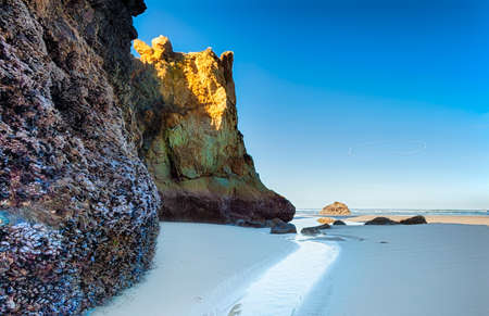 Here a watery path leads the eye past huge rock formations to the surf beyond.; One of several meditative places on Arcadia; on the Oregon coast where one can contemplate the beyond.の写真素材