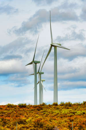 Wind turbines stand above sagebrush and under cloudy skies in south eastern Washington State.の写真素材
