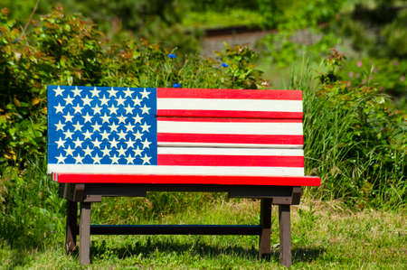 A bench with the American Flag Painted on it.の写真素材