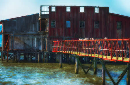 One iconic sight seen along Astoria's waterfront is this old decaying net loft.  It's faded and weathered exterior and missing or broken windows draws the eye.の写真素材