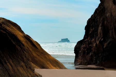 Intertidal rocks on Arcadia Beach on the Oregon coast frame the view of another huge rock out in the ocean.の写真素材