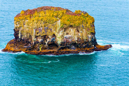 A rock Island surrounded by the Pacific ocean is a favorite resting place for birds as is evident to the streaks of bird dropping staining the sides of the island.  This island can be seen from Cape Mears Lighthouse as it is very close to the coastline.の写真素材