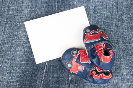 pair of baby shoes on jeansの写真素材