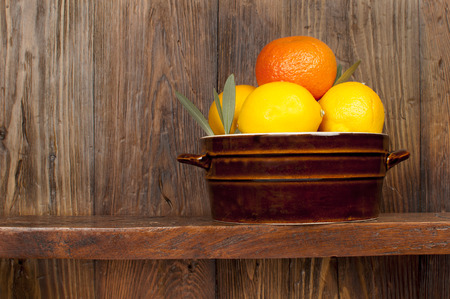 fruits: lemons and oranges on a wooden tableの写真素材