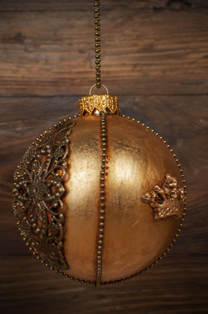 handmade golden chrostmas ball on wooden backgroundの写真素材