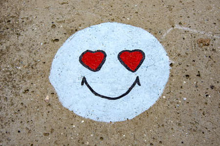 Emoticon is drawn in chalk on the road. Cheerful smileの写真素材