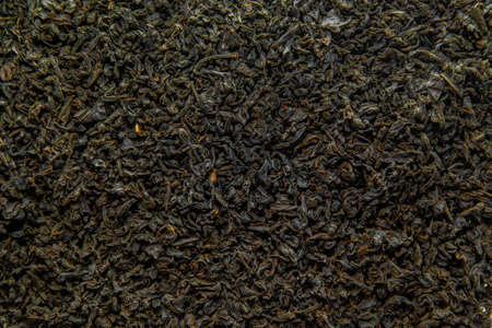 Black tea as a background. Black tea is scattered. Tea leaves are dried.