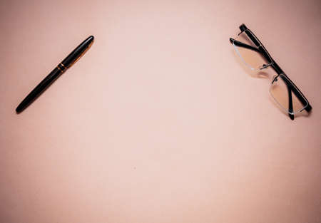 Pen and glasses in different places on the table. The pen is used for signatures and writing. Glasses are needed for people with poor eyesight.の写真素材