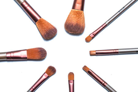 Makeup brushes are stacked in a circle on a white background. Professional brushes for applying eye...