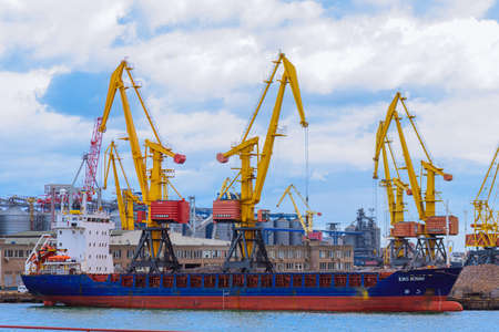 Loading ship in the port of Odessa. Port cranes are loading wheat on the ship.