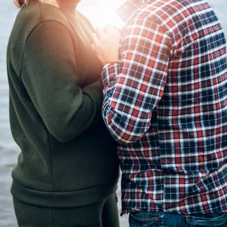 A guy and a girl hugging and holding hands. The warmth of love, the glare of the sunの写真素材