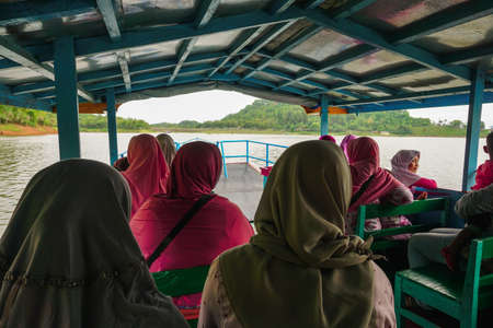Kebumen, Central Java, Indonesia (12/30/2018) : A group of visitors aboard a boat tour around the Sempor Damのeditorial素材