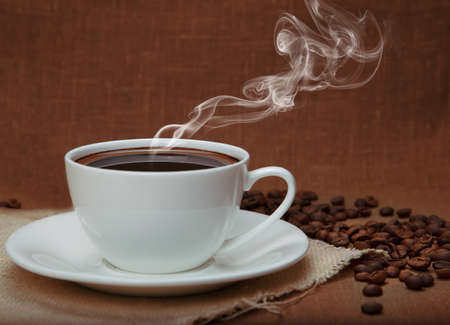 steaming coffee on flax backgroundの写真素材