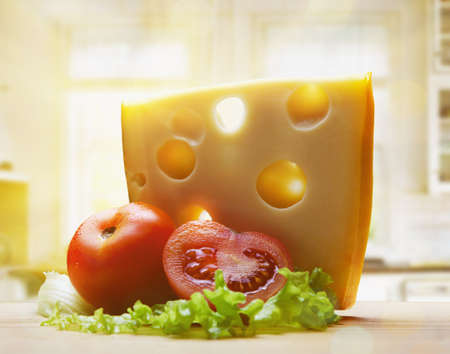 cheese with tomatoes in morning summer light at the kitchenの写真素材