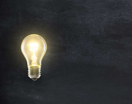 Light bulb lamp on blackboard background with copy spaceの写真素材