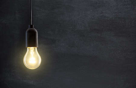 Light bulb lamp on blackboard background with copy spaceの写真素材