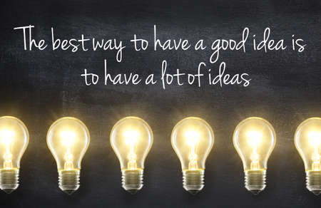 Light bulb lamps on blackboard background with idea quote