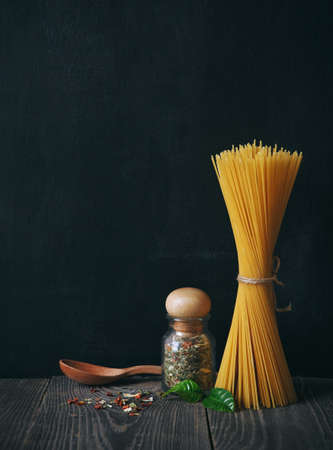 spaghetti and spices on blackboard background. copy spaceの写真素材