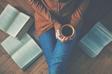 girl having a break with cup of fresh coffee after reading books or studying