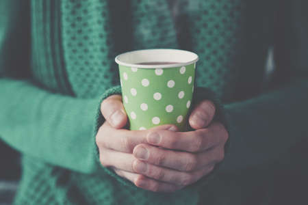 hands holding paper cup with take-out coffeeの写真素材