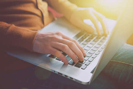 hands with laptop typing in sunlight
