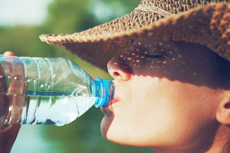 Woman drinking water in summer sunlight Woman drinking water in summer sunlight