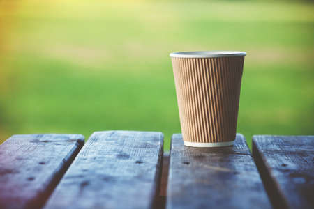paper cup of coffee on natural outside backgroundの写真素材