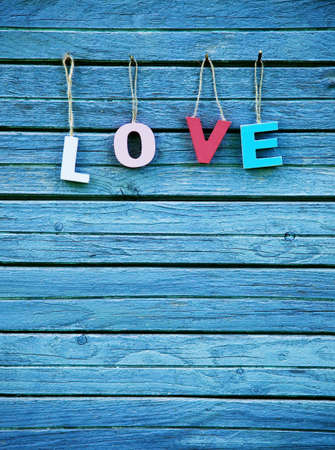 The word Love with wooden multi colored letters on natural board background. Copy spaceの写真素材