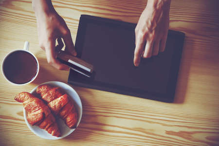 Hands holding credit card and using digital tablet pc. View from aboveの写真素材