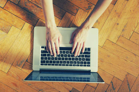 Hands using laptop and typing. View from aboveの写真素材