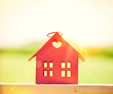 red model of house as symbol on sunlight backgroundの写真素材