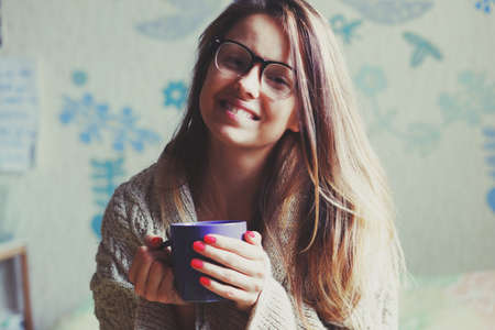cheerful girl drinking coffee in bedの写真素材