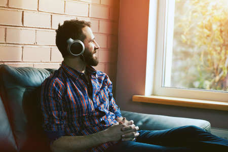 smiling bearded man  in headphones listening to music
