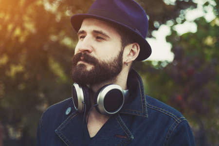bearded man  with hat and headphones listening to music