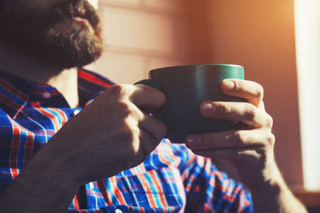 bearded man hands with cup of tea or coffeeの写真素材