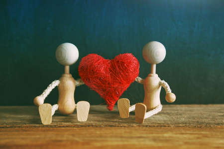 Two wooden little men with heart. Love concept or valentines cardの写真素材