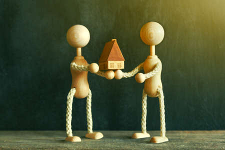 wooden little men with new house modelの写真素材