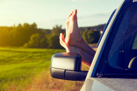 Woman legs out car window. Freedom or travelling conceptの写真素材