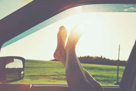 Woman legs out car window. Freedom or travelling conceptの写真素材