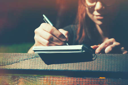 girls hand writing with pen on wooden desk