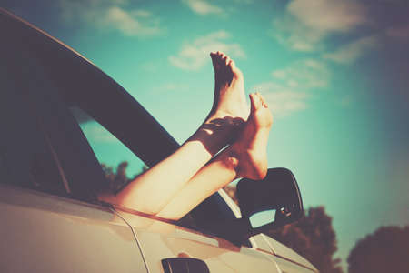 Woman legs out car window. Freedom or travelling conceptの写真素材