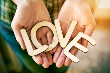 Hands holding wooden letters with word love. Love conceptの写真素材