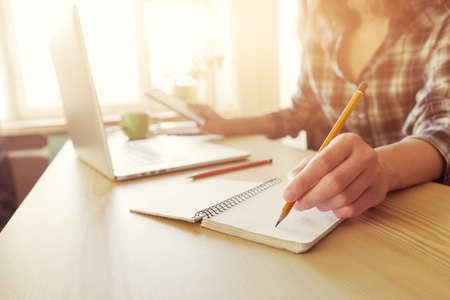 hand with pencil and notebook at workplaceの写真素材