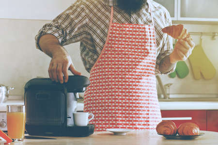 man making morning espresso with coffee machine while breakfast at kitchen
