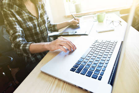 designers hands with tablet and laptop at tableの写真素材